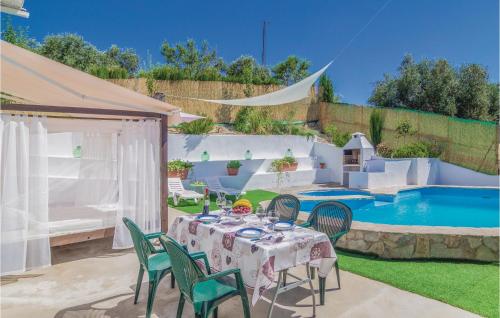 una mesa y sillas en un patio con piscina en Stunning Home In Rute, en Zambra