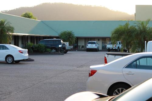 a parking lot with cars parked in front of a building at Glenmore Palms Motel in Rockhampton