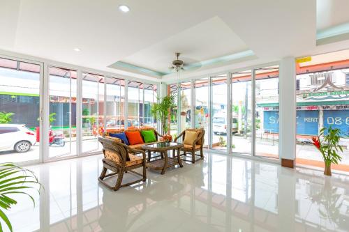 a lobby with a table and chairs and windows at Phusita Hotel - SHA Certified in Patong Beach