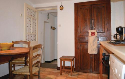 a kitchen with a table and a wooden door at Stunning Apartment In Calcatoggio in Calcatoggio