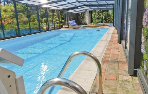 a large swimming pool with a glass wall at Awesome Home In Saint Pabu With Sauna in Saint-Pabu