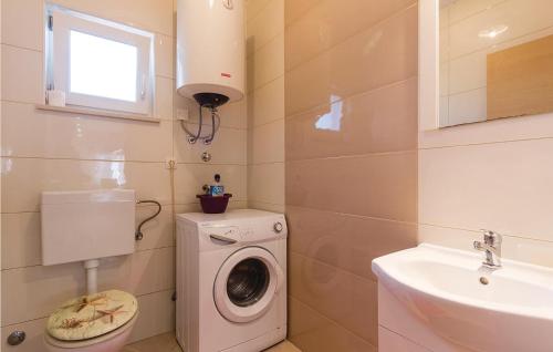 a bathroom with a washing machine and a sink at Amazing Home In Galizana With Kitchen in Galižana