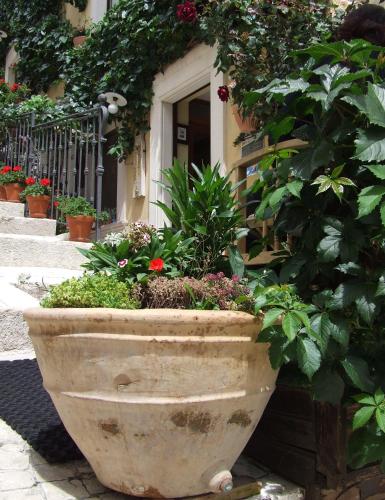a large stone planter with flowers in front of a building at Garnì B&B La Rua-Pescocostanzo in Pescocostanzo