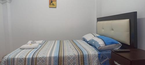 a bedroom with a large bed with blue pillows at La Petite Maison in Nazca