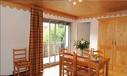 une salle à manger avec une table et des chaises et une fenêtre dans l'établissement Résidence Les Glaciers, à Samoëns