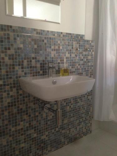 a sink in a tiled bathroom with a mirror at Sanderau NA29 in Würzburg