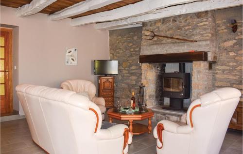 a living room with two white chairs and a stone fireplace at Awesome Home In Le Cambout With Wifi in Le Cambout