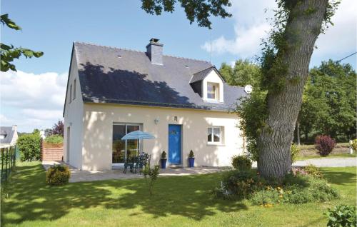 une maison blanche avec une porte bleue et un arbre dans l'établissement 3 Bedroom Beautiful Home In Guehenno, à Guéhenno