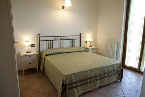 een slaapkamer met een bed en twee nachtkastjes met lampen bij Residence Colle Veroni in Mosciano SantʼAngelo
