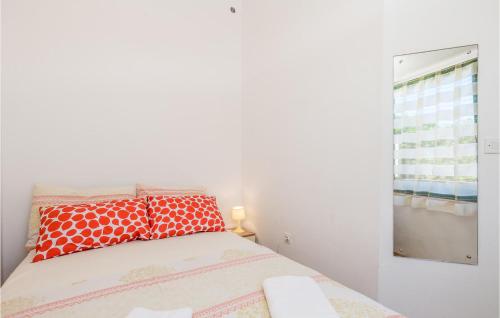 ein kleines Schlafzimmer mit einem Bett mit roten Kissen in der Unterkunft Nice Apartment In Potocnica With 1 Bedrooms And Wifi in Borovići
