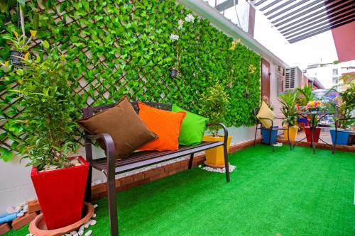 a patio with a bench with colorful pillows on it at Phusita Hotel - SHA Certified in Patong Beach