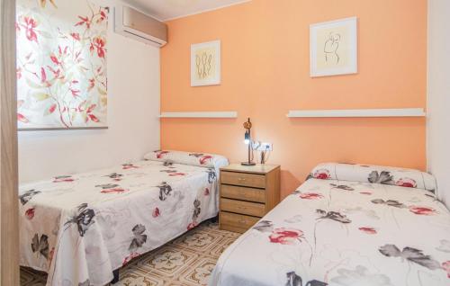 2 camas en una habitación con paredes de color naranja en Stunning Apartment In Crdoba With 2 Bedrooms And Wifi en Córdoba