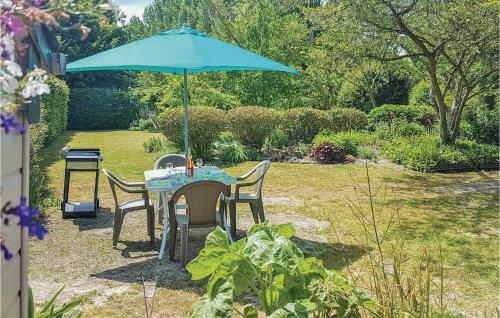 a table with a blue umbrella in a garden at Gorgeous Home In Mont-Dol With Wifi in Mont-Dol