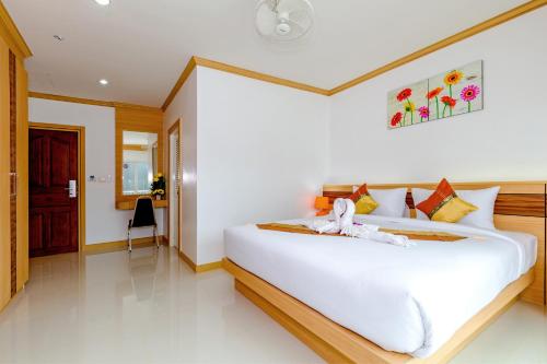 a white bedroom with a large white bed at Phusita Hotel - SHA Certified in Patong Beach