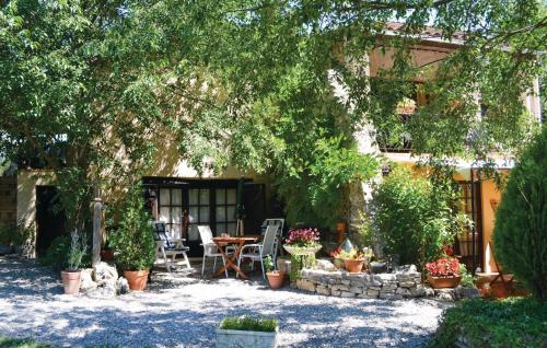 un patio avec une table et des chaises sous un arbre dans l'établissement 1 Bedroom Amazing Apartment In Lorgues, à Lorgues