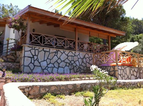a house with a stone retaining wall and flowers at Villa Aktan in Kas