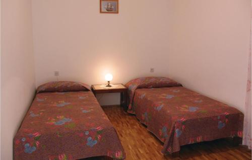 a room with two beds and a table with a lamp at Awesome Apartment In Miskovici With 4 Bedrooms in Miškovići