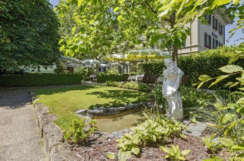 a statue of a cat in a garden at Hotel Landgasthof Schönbühl in Schönbühl