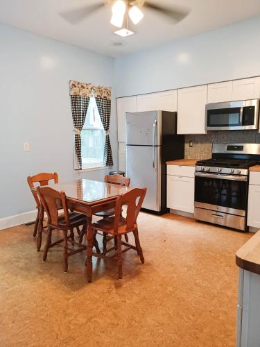 a kitchen with a table and chairs and a refrigerator at Huge 2 Bedroom House in the Heart of Northside! in Cincinnati