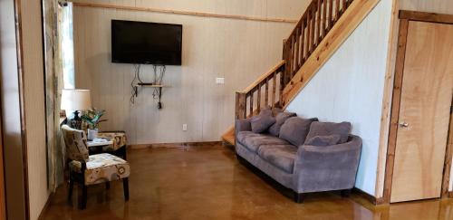 a living room with a couch and a tv at Seven Bluff Cabins in Concan