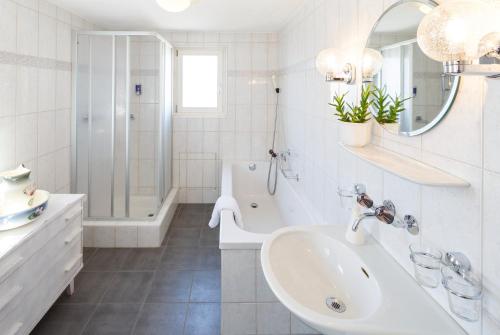 biała łazienka z umywalką, wanną i prysznicem w obiekcie Hotel Landgasthof Schönbühl w mieście Schönbühl
