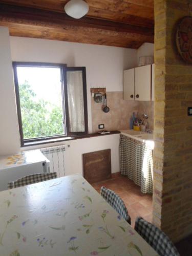 a kitchen with a table and chairs and a window at Agriturismo Via del Campo in Pianella