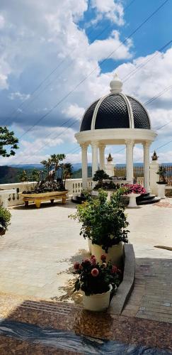 a gazebo with flowers in pots in a courtyard at Dream Boutique Hotel in Da Lat