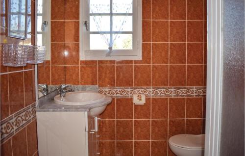 a bathroom with a sink and a toilet and a window at Amazing Home In Saint Cast Le Guildo With 2 Bedrooms in LʼIsle-Saint-Cast