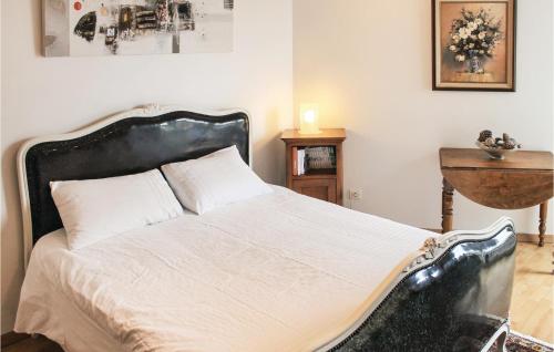 una camera con un grande letto con testiera nera di Stunning Home In Plouarzel With 2 Bedrooms, Wifi And Indoor Swimming Pool a Rubian