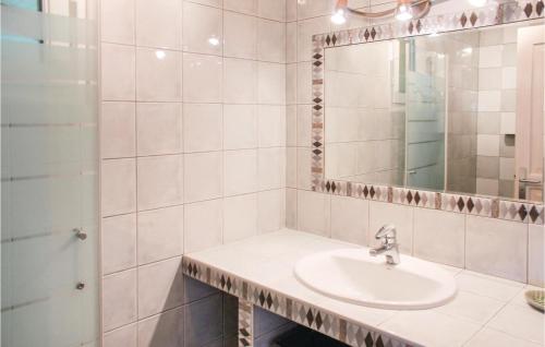 La salle de bains blanche est pourvue d'un lavabo et d'un miroir. dans l'établissement Beautiful Home In Plouarzel With Indoor Swimming Pool, à Rubian