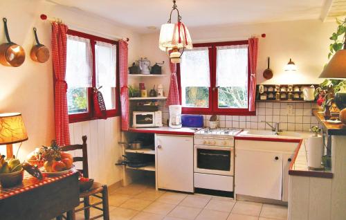 - une cuisine avec des appareils électroménagers blancs et des fenêtres rouges dans l'établissement Awesome Home In Bénodet With Wifi, à Bénodet