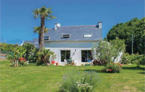 a white house with a palm tree in a yard at Awesome Home In Bénodet With Wifi in Bénodet