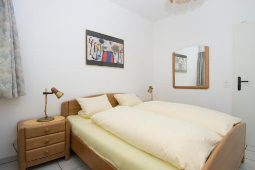 ein Schlafzimmer mit einem Bett und einer Lampe auf einem Nachttisch in der Unterkunft Collina d'Oro Orselina Locarno in Locarno