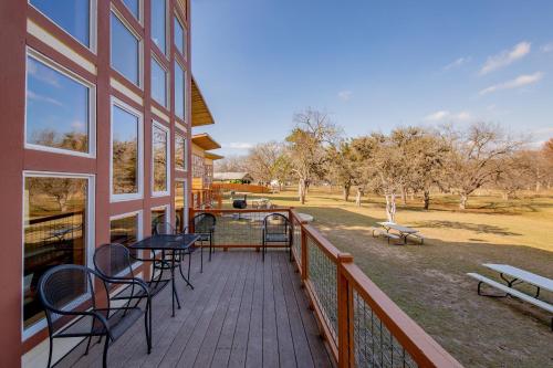 a balcony of a building with tables and chairs at Seven Bluff Cabins in Concan