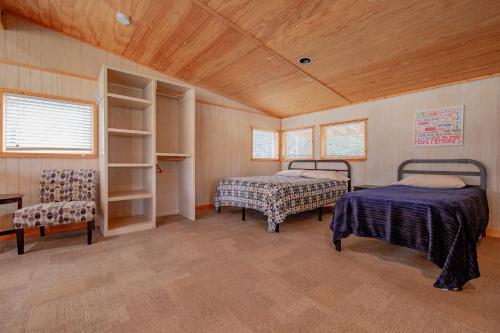 a room with two beds and two chairs in it at Seven Bluff Cabins in Concan