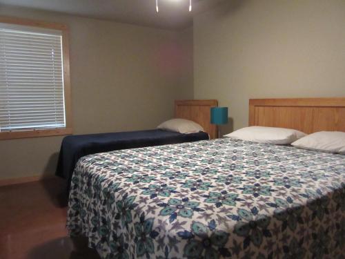 a bedroom with a bed with a flowered blanket at Seven Bluff Cabins in Concan