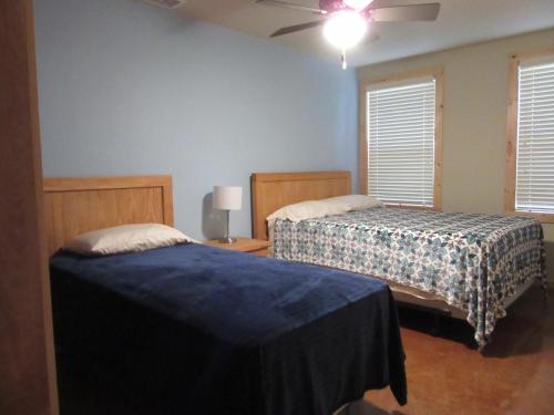 a bedroom with two beds and a ceiling fan at Seven Bluff Cabins in Concan