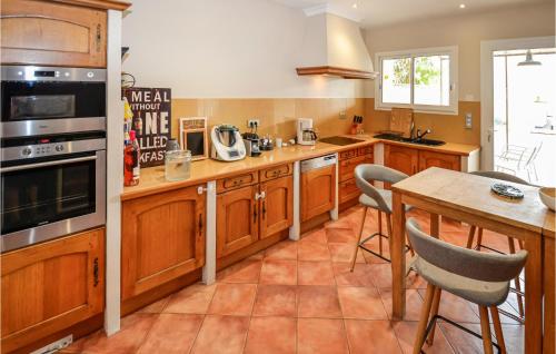 une cuisine avec des armoires en bois et une table avec des chaises dans l'établissement Awesome Home In Chateuneuf De Gadagne, à Châteauneuf-de-Gadagne