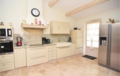 une cuisine avec des armoires blanches et un réfrigérateur en acier inoxydable dans l'établissement 4 Bedroom Cozy Home In Eygalières, à Eygalières