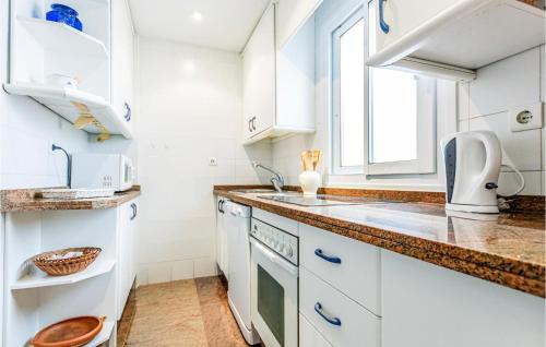 a kitchen with white cabinets and a sink and a window at Stunning Apartment In La Herradura-almuecar With Kitchen in La Herradura