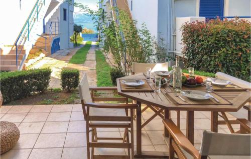 a wooden table with a bowl of fruit on a patio at Awesome Apartment In Melissi Korinthia in Dhiminión