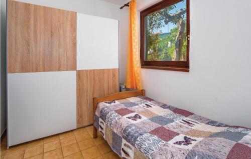 a bedroom with a bed and a window at 1 Bedroom Pet Friendly Apartment In Labin-ravni in Ravni