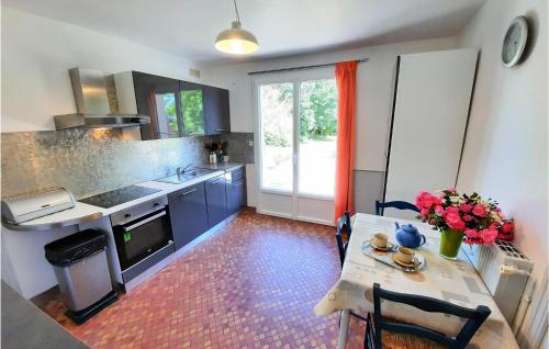 - une cuisine avec une table et des fleurs dans l'établissement Stunning Home In Concarneau With Wifi, à Concarneau