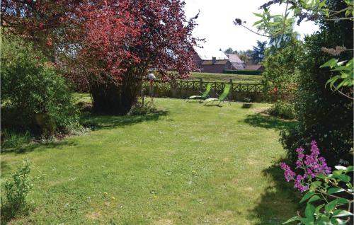 a garden with a fence and flowers in the grass at Lovely Home In Frise With Wifi in Frise