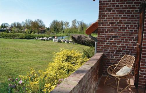 a chair sitting on a brick wall next to a yard at Lovely Home In Frise With Wifi in Frise