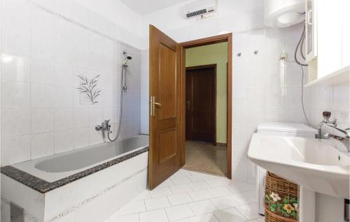 a bathroom with a tub and a toilet and a sink at Amazing Home In Jurdani With Kitchen in Jurdani