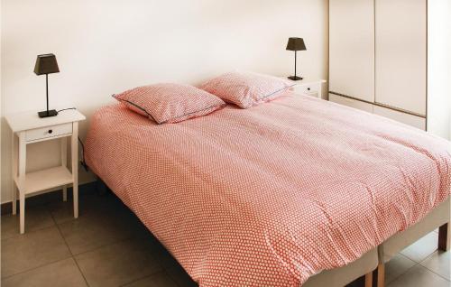 Un dormitorio con una cama con dos mesitas de noche y dos lámparas. en Stunning Home In Erdeven With Wifi, en Erdeven
