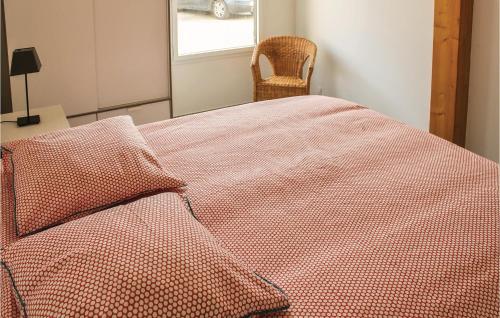 - une chambre avec un lit doté d'une couette rouge et d'une chaise dans l'établissement Stunning Home In Erdeven With Wifi, à Erdeven