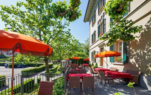 a patio with tables and umbrellas next to a building at Hotel Landgasthof Schönbühl in Schönbühl