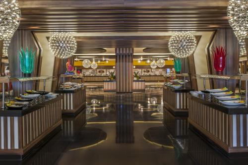 a dining room with chandeliers and tables in a restaurant at Botanik Platinum Hotel in Okurcalar